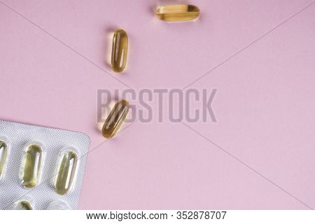 Oil Yellow Capsules On Pink Background, Vitamins And Antioxidant Concept Omega 3, Liver Cod Or Eveni
