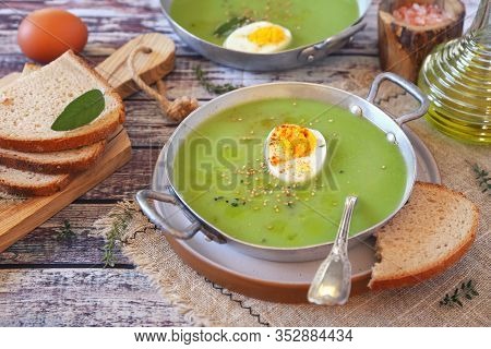 Green Pea Soup With Spinach, Olive Oil, Sesame And Half Boiled Egg Dressing In Two Bowls. Rustic Sty