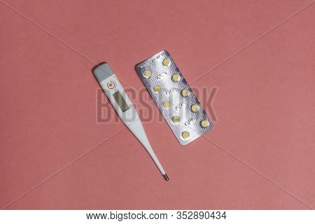 Electronic Thermometer And Pill On The Background. Top View