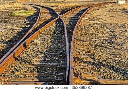 Rusty Railroad Tracks Splitting Off Into Two Different Directions With Each Ending Abruptly