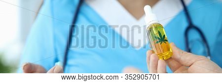 Focus On Male Hand Giving Bottle Of Cannabinoid Oil To Professional Wonderful Doctor. Pretty Woman I