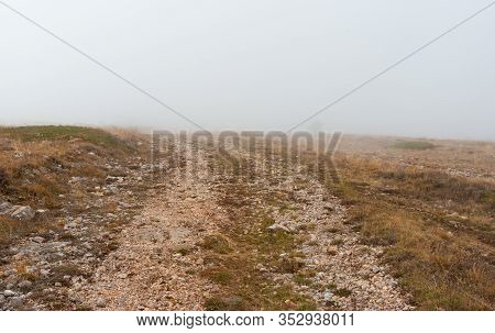 Autumnal Landscape With Empty Medieval Rocky Road In Fog On Babuhan Yaila Natural Reserve,  On Crime