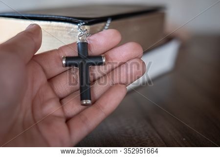 The Crucifix Lay On The Palm Of The Hand,bible Background And Close-up Images Of Praying For The Ble