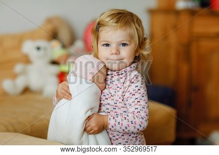 Adorable Cute Little Toddler Girl Playing With Doll. Happy Healthy Baby Child Having Fun With Role G