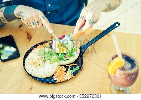 Man Eating Egg Hamburger Bread And Vegetarian Salad In The Restaurant. Salad With Egg, Bread And Car