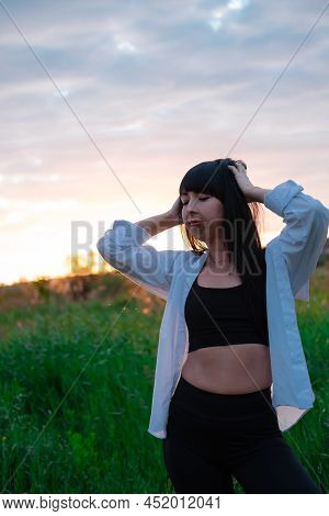 Brunette Woman In White Blouse With Baldric On Summer Field On Sunset. Peaceful Time. Millennial Gen
