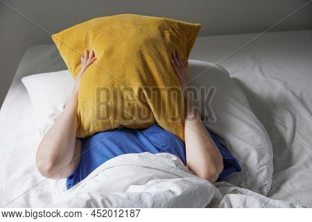 Unrecognizable Person Lying In Bed And Hiding Face Under Pillow Feeling Tired And Listless