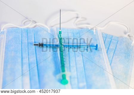 A Blue Mask With A White Background And A Syringe For Injection For Healthcare Workers And People At