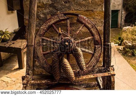 A Rustic Wooden Wheel With Pine Tree Cones In Poffabro, An Historic Medieval Village In The Val Colv