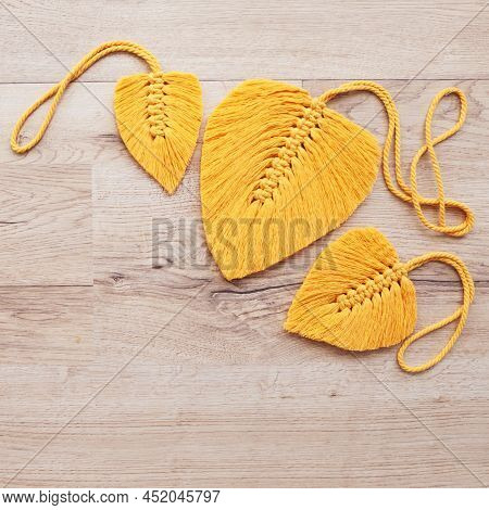 Macrame Leaves In Yellow Color On The Wooden Background. Cotton Rope Decor Macrame To Make Your Home