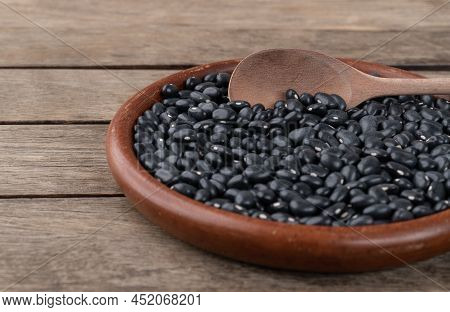 Black Beans In A Plate Over Wooden Table. Short Depth Of Field.