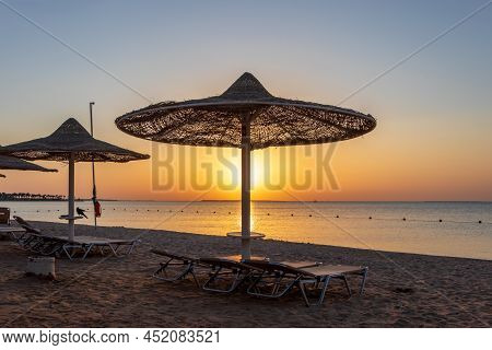 Sunrise On The Beach With Parasol Overlooking The Red Sea In Hurghada, Egypt