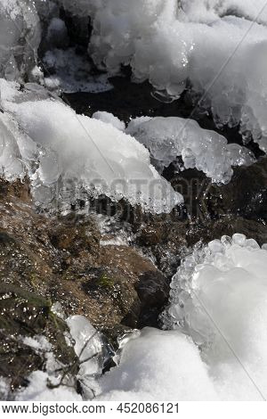 Spring Sunlit Streamlet Among Ice And Snow Close-up