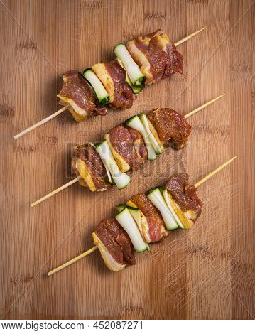 Raw Lamb Skewers With Zucchini Slices On Wood High Quality Photo