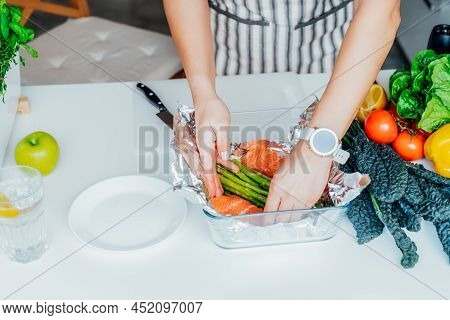 Baked Salmon With Green Asparagus Recipe Steps. Step Two. Woman Putting Sliced Fresh Salmon Into The