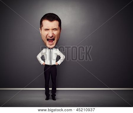 어두운 배경 위에 큰 머리와 화가 사업가의 전신 사진