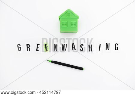 Greenwashing Concept With Green And Black Pen And Plastic House. Greenwashing Marketing Ploy Product
