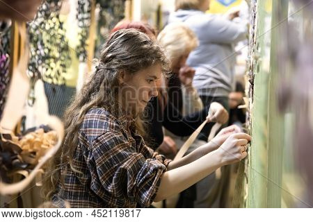 Kyiv, Ukraine - Apr. 01, 2022: A Group Of Volunteers In A Shelter Making Camouflage Net, From Differ