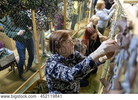 Kyiv, Ukraine - Apr. 01, 2022: A Group Of Volunteers In A Shelter Making Camouflage Net, From Differ