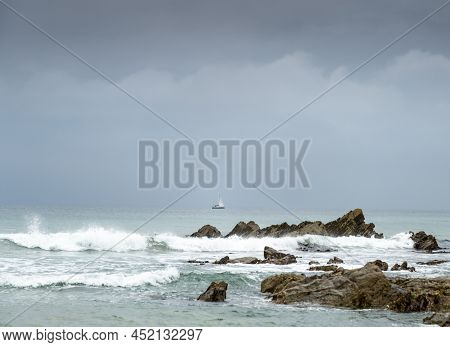Jagged Rock Pinnacles Juxtaposed With Distant Sailing Boat,dollar Cove,gunwalloe, Helston,south Corn