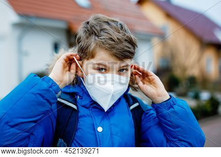 Kid Boy Wearing Ffp Medical Mask On The Way To School. Child Backpack Satchel. Schoolkid On Cold Aut