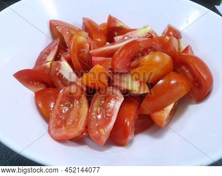 Top View Of Tomatoes Sliced In White Bowl Isolated On White Background (solanum Lycopersicum Var. Ce