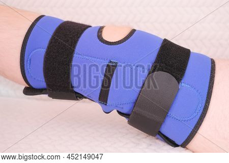 Blue Bandage On The Knee Joint, Orthosis On The Knee Joint After Injury Or Surgery. Close-up, Male K
