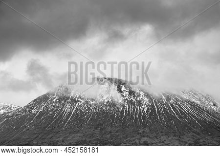 Black And White Beautiful Winter Landscape Image Of Beinn A' Chaladair In Scotland With Dramatic Ski
