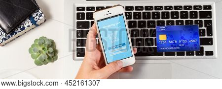 On-line Shopping Concept - Desktop With Laptop, Credit Card And Hands Holging Phone With On-line Sho