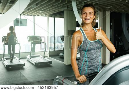 Young And Sporty Woman On Treadmill In Gym