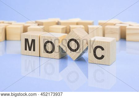 Four Wooden Blocks With The Letters Mooc On The Bright Surface Of A Pale Lilac Table. The Inscriptio