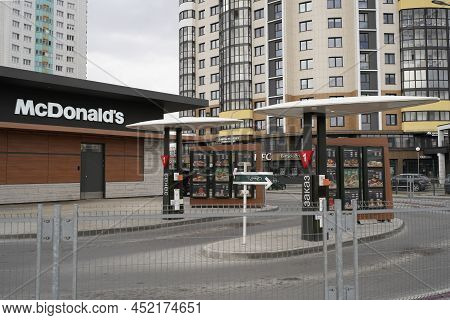 Mcdonald's Service Drive Thru On Background Of High-rise Buildings Of City. Driver Ordering Food At 
