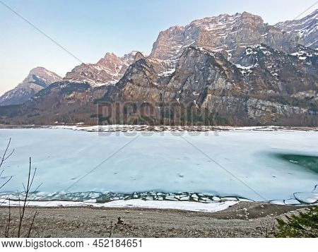 Frozen Klöntalersee Or Klontaler Lake During Early Spring In The Alpine Valley Klöntal (kloental Or 