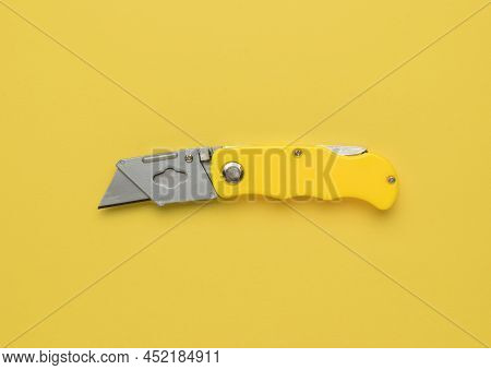 Yellow Folding Knife On A Yellow Background. Minimalistic Concept. Flat Lay.