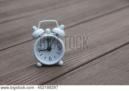 White Alarm Clock Set At 9 O\'clock. Morning Concept.