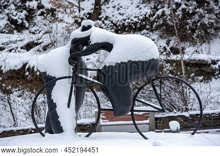 Escaldes Engordany, Andorra: 2022 April 2: Sculpture By Botero Cyclist And Woman Kiss. Whit Snowfall