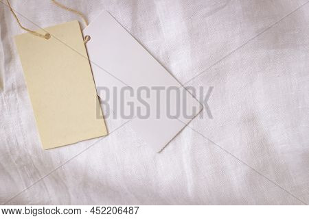 Blank Price Label Tag Paper Card On White Natural Linen Fabric Shirt. Clothes Label Tag Mockup Templ