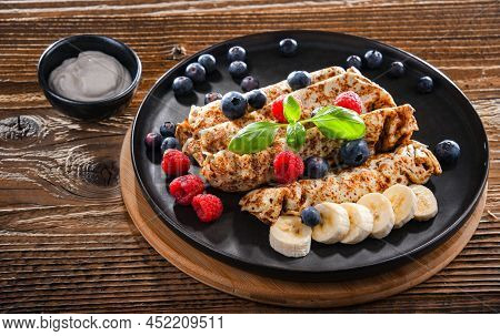 A Plate Of Pancakes With Cheese And Fruits
