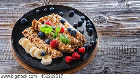 A Plate Of Pancakes With Cheese And Fruits