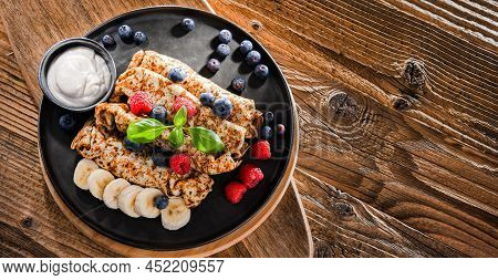 A Plate Of Pancakes With Cheese And Fruits