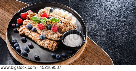A Plate Of Pancakes With Cheese And Fruits