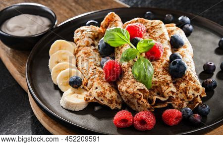 A Plate Of Pancakes With Cheese And Fruits