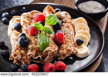 A Plate Of Pancakes With Cheese And Fruits