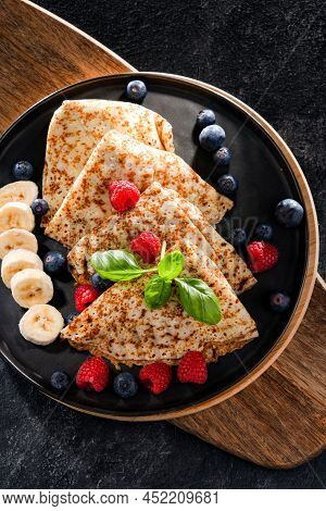 A Plate Of Pancakes With Cheese And Fruits