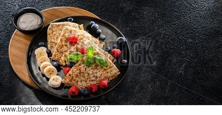 A Plate Of Pancakes With Cheese And Fruits