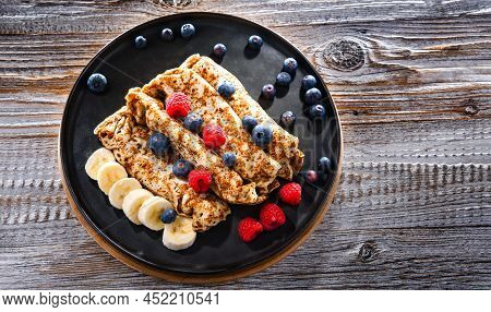 A Plate Of Pancakes With Cheese And Fruits