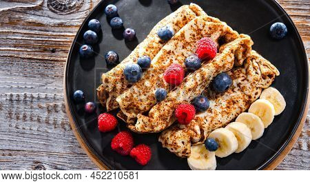 A Plate Of Pancakes With Cheese And Fruits