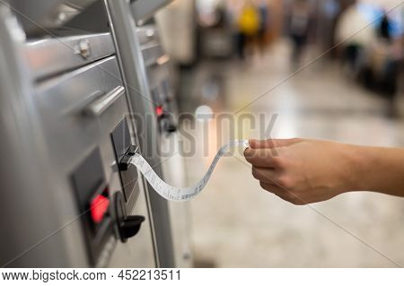 A Woman Takes A Train Ticket From A Self-service Ticket Office.