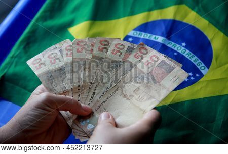 Brazilian Money Next To A Flag