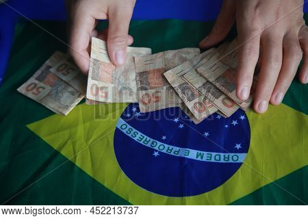 Brazilian Money Next To A Flag